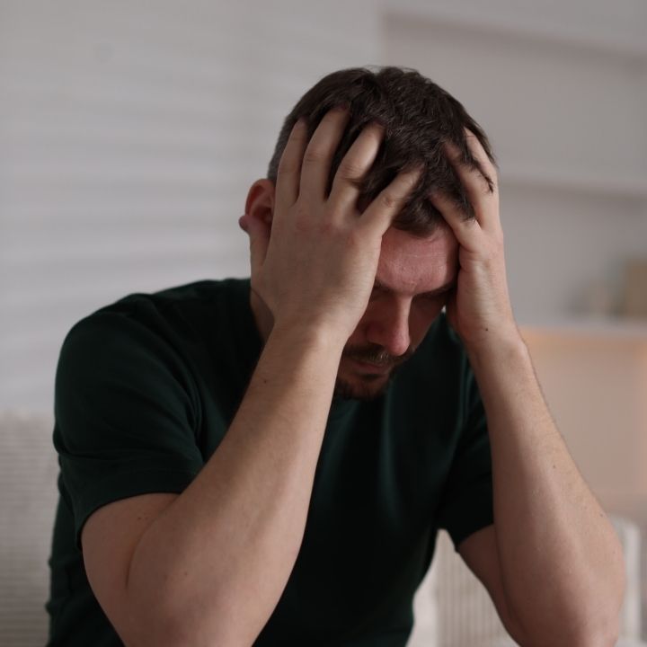Man sitting with his head in his hands during a difficult moment.
